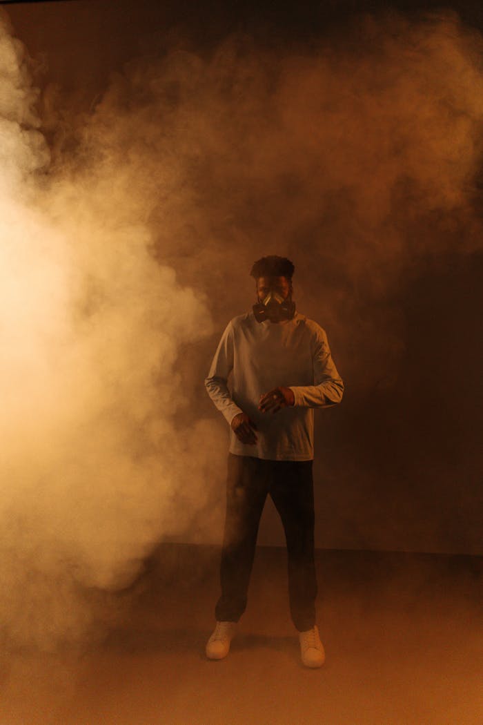 A man wearing a gas mask stands in thick smoke, highlighting air pollution concerns.